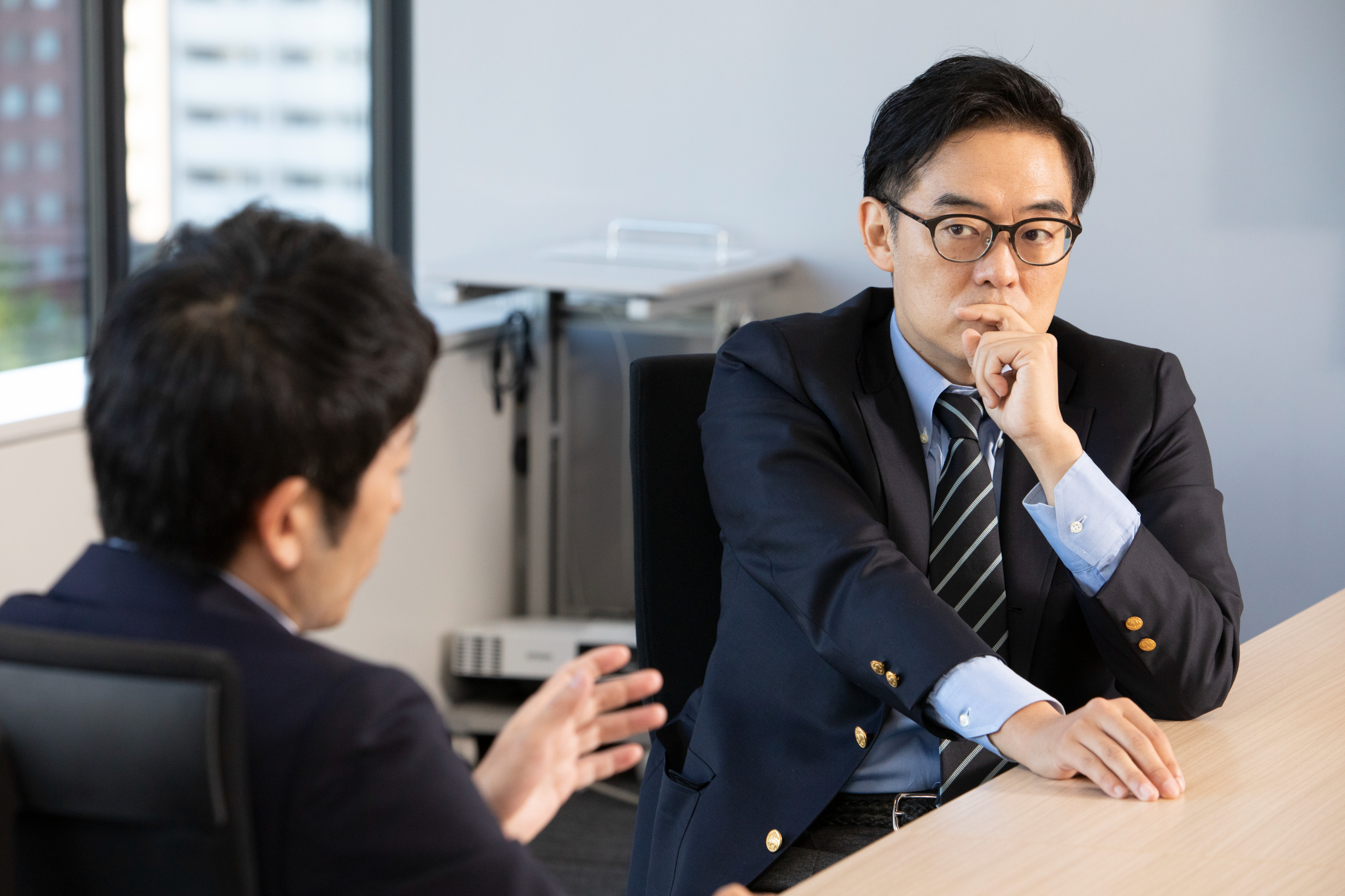 産業医の大室正志さん(写真右)。産業医科大学産業医実務研修センター、ジョンソン・エンド・ジョンソン統括産業医や医療法人社団同友会の産業保健部門を経て、独立。現在、大企業からベンチャー、外資、独立行政法人まで30社以上の産業医を担当。著書に『産業医が見る過労自殺企業の内側』(集英社新書)など。