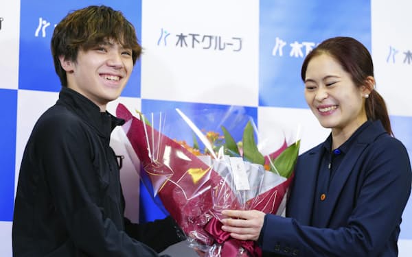 引退の会見で宇野昌磨（左）から花束を受け取り、笑顔を見せるフィギュアスケート女子の宮原知子（1日）＝共同