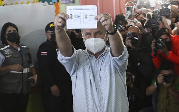 大統領選の決選投票で投票用紙を掲げる国民解放党のホセ・マリア・フィゲレス元大統領＝ＡＰ