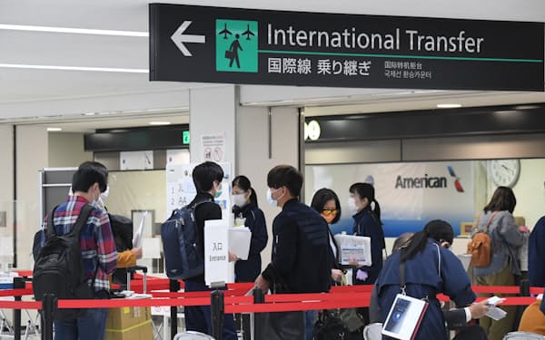 入国のため書類確認の窓口で手続きを待つ人たち（成田空港）
