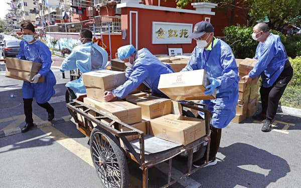 都市封鎖が続く中国上海市で、居住区に支援物資を届ける担当者ら（8日）＝CNS共同