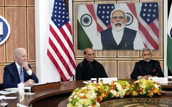 11日、バイデン米大統領㊧とスクリーンに映るインドのモディ首相＝ＡＰ