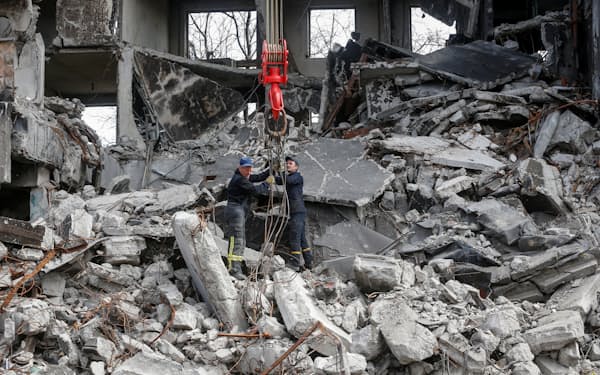 破壊された建物のがれきを撤去する作業員ら（10日、マリウポリ）＝ロイター