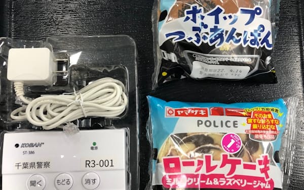 菓子パンのパッケージで詐欺への注意を訴える。左は千葉県警が配る通話録音警告機器