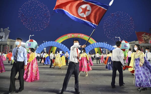 　平壌の金日成広場で行われた「太陽節」を祝う舞踏会で北朝鮮国旗を振る参加者＝15日（共同）