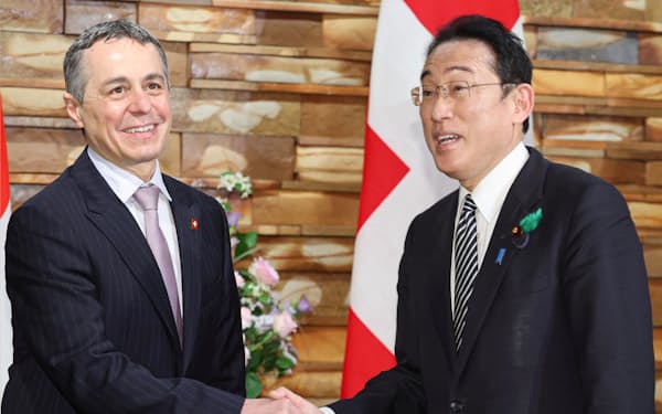 会談を前に握手するスイスのカシス大統領㊧と岸田首相（18日、首相官邸）