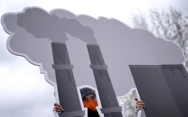 ドイツのベルリンで発電所を描いたプラカードを掲げて化石燃料の利用に反対する人たち＝ＡＰ