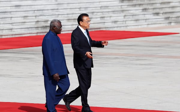 中国とソロモン諸島は関係を 強化している（2019年、北京を訪問したソロモンのソガバレ首相㊧）＝ロイター