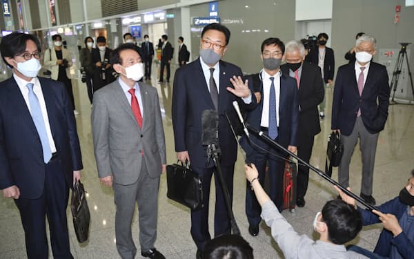 24日、仁川国際空港で記者団の質問に答える韓国の鄭鎮碩国会副議長（左から3人目）＝共同