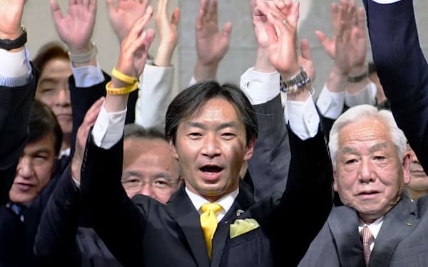 参院石川選挙区補選で当選を決め、万歳する宮本周司氏(中央)=24日夜、金沢市(共同)