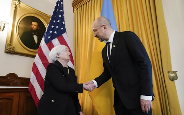 ウクライナのシュミハリ首相（右）と握手するイエレン米財務長官（21日、ワシントン）＝AP