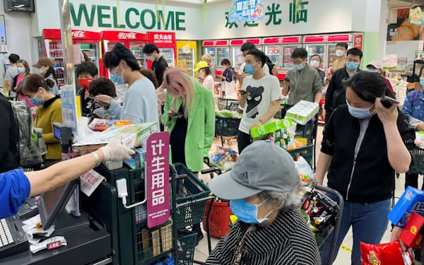 北京のスーパーマーケットで行列をつくる人々（24日）＝ロイター