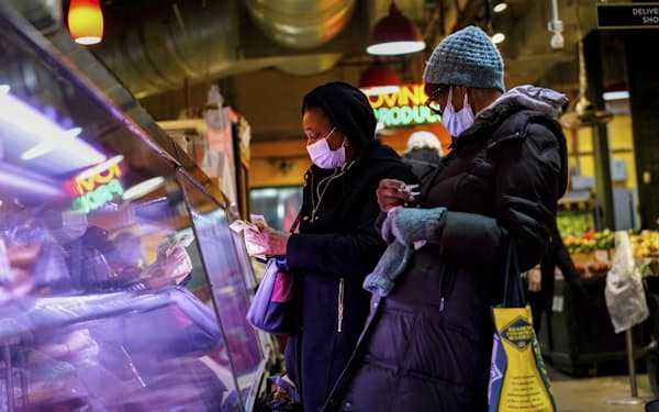 FILE - Customers wear face masks to protect against the spread of the coronavirus as they shop at the Reading Terminal Market in Philadelphia, Feb. 16, 2022.  COVID cases are starting to rise again in the United States, with numbers up in most states and up steeply in several. One expert says he expects more of a “bump&quot; than the monstrous surge of the first omicron wave, but another says it’s unclear how high the curve will rise and it may be more like a hill. (AP Photo/Matt Rourke, File)