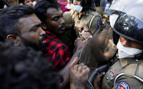 スリランカの首相官邸近くで、物価高騰に抗議して警官隊ともみ合う市民ら（24日、コロンボ）＝ロイター
