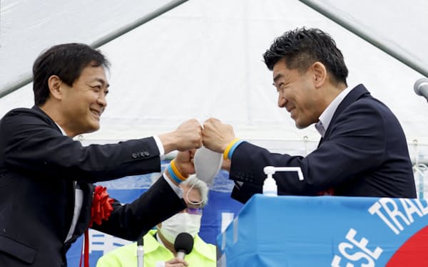 大阪市で開かれたメーデー大会で、タッチを交わす国民民主党の玉木代表（左）と立憲民主党の泉代表（1日）＝共同