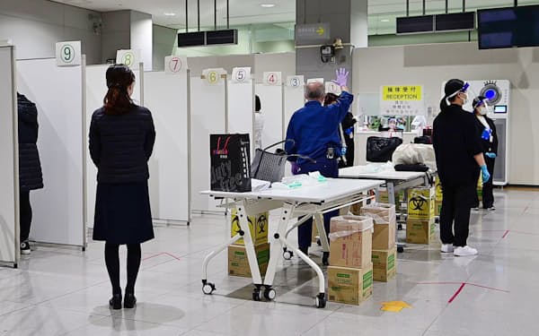 抗原検査のため入国者の検体採取を行う検疫所の職員ら（3月1日、関西国際空港）