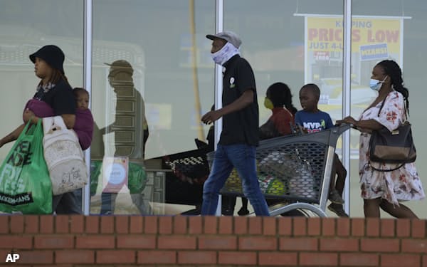 Customers, some wearing mask walks out of shop at a mall in Vosloorus, east of Johannesburg, South Africa, Saturday, April 30, 2022. South Africa is seeing a rapid rise in COVID-19 cases driven by yet another version of the coronavirus, health experts say. (AP Photo/Themba Hadebe)