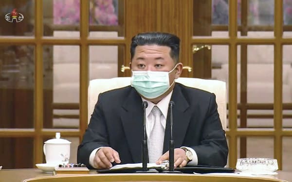 朝鮮労働党の政治局会議の冒頭、マスクを着けて臨む金正恩総書記。北朝鮮の朝鮮中央テレビが12日放映＝共同