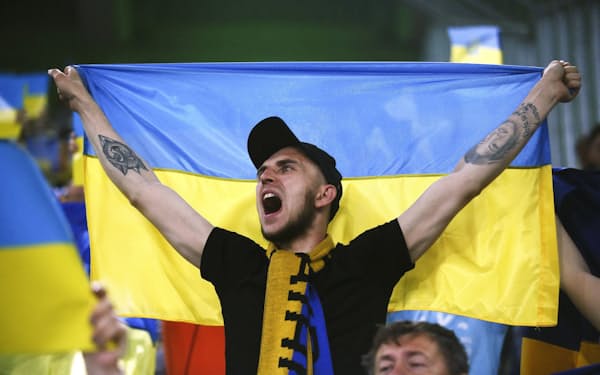 サッカー・ドイツ1部リーグのボルシアMGに勝利し、国旗を掲げるウクライナ代表のサポーター（11日、ドイツのメンヘングラッドバッハ）＝ロイター