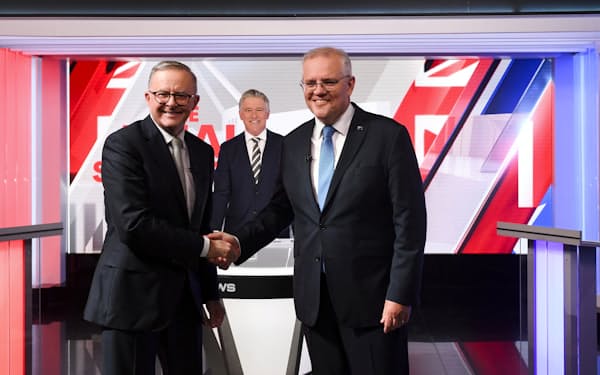 総選挙に向けた討論会でモリソン首相（右）と握手する労働党のアルバニージー党首（11日、シドニー）＝ロイター