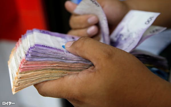 現金から電子マネーへの移行が加速する見通し(フィリピンのペソ紙幣)=ロイター