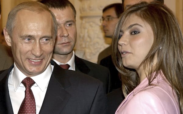 　アリーナ・カバエワさん㊨の隣で笑顔を見せるロシアのプーチン大統領（2004年11月、モスクワのクレムリン）＝ロイター