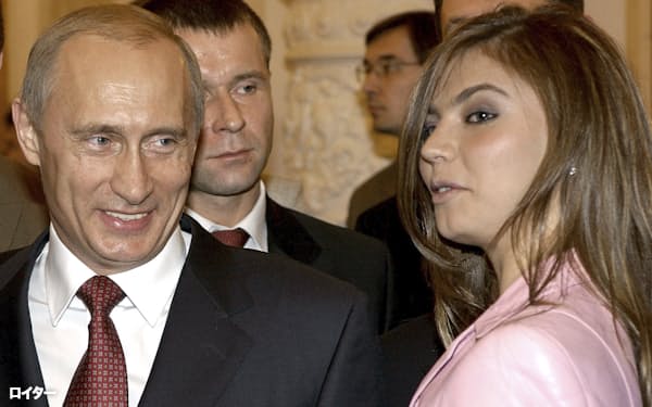  アリーナ・カバエワさん㊨の隣で笑顔を見せるロシアのプーチン大統領(2004年11月、モスクワのクレムリン)=ロイター