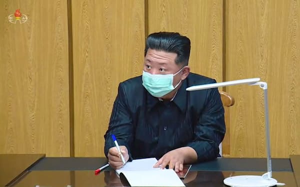 「国家非常防疫司令部」を視察するマスク姿の金正恩党総書記。北朝鮮の朝鮮中央テレビが13日放映した（共同）