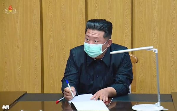 「国家非常防疫司令部」を視察するマスク姿の金正恩党総書記。北朝鮮の朝鮮中央テレビが13日放映した(共同)