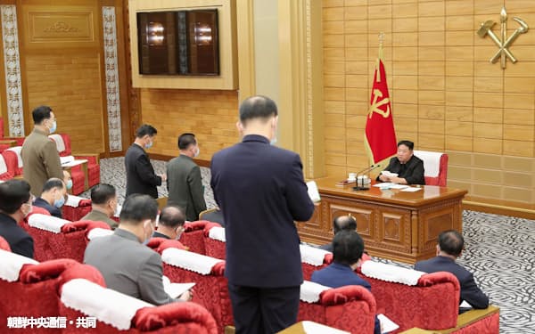 14日の会議で新型コロナウイルスについて報告を受ける金正恩氏(右奥)=朝鮮中央通信・共同