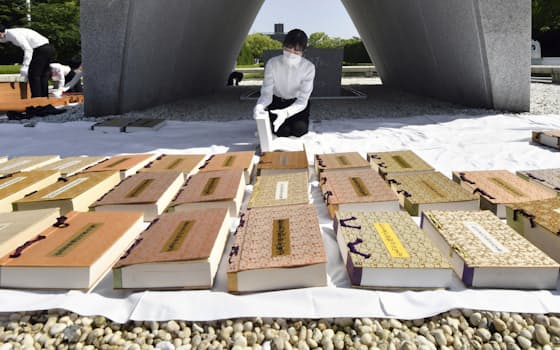 原爆慰霊碑前で行われた、原爆死没者名簿の「風通し」（18日午前、広島市の平和記念公園）=共同