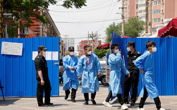 北京市内のコロナ管理地区は仮設の青い柵で厳重に防護され、住民が逃げ出さないよう監視員が常駐している=ロイター