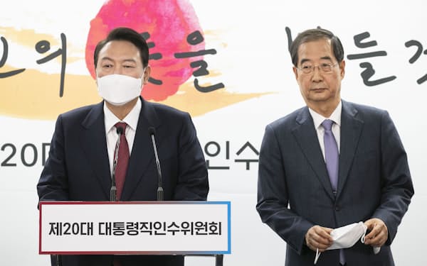 首相に就任する韓悳洙氏（右）と尹錫悦大統領＝聯合・共同