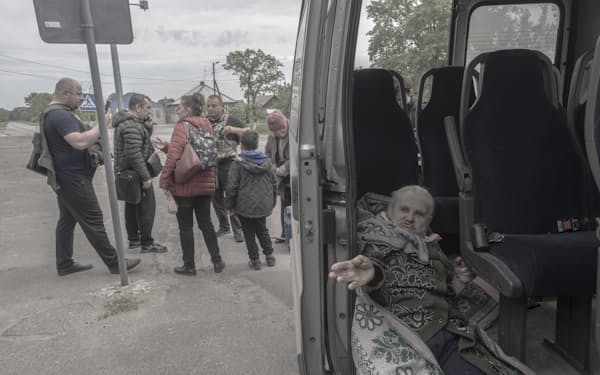 21日、セベロドネツク近くの町から避難する民間人=AP