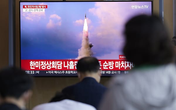 北朝鮮のミサイル発射を伝えるニュースを見る人たち(25日、ソウル)=AP