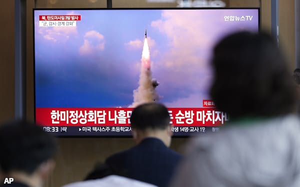 北朝鮮のミサイル発射を伝えるニュースを見る人たち(25日、ソウル)=AP