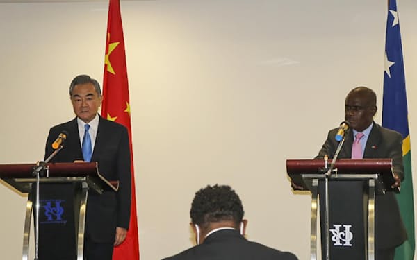 26日、ホアニラで、共同記者会見に臨む中国の王毅国務委員兼外相（左）とソロモン諸島のマネレ外務・貿易相=AP