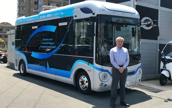 EVモーターズ・ジャパンの佐藤裕之社長と試乗用のバス（22年5月、北九州市）