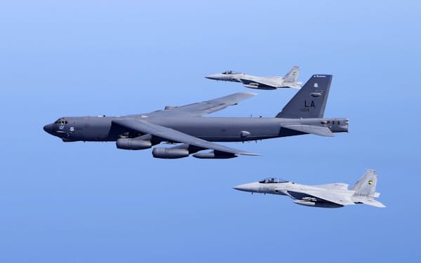 　共同訓練する米空軍のB52爆撃機（中央）と航空自衛隊のF15戦闘機＝2018年7月、日本海上空（航空自衛隊提供）