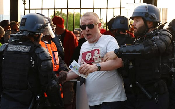 競技場の入場口付近で警察に取り押さえられるリバプールのファン（5月28日、パリ郊外サンドニ）=ロイター