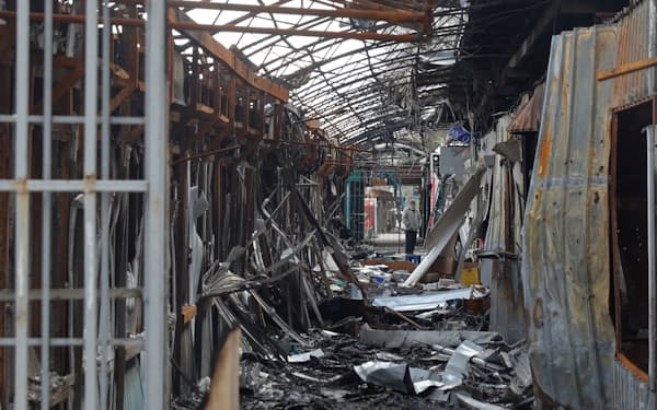 破壊された市場に立つ住民（4月、ウクライナ東部セベロドネツク）=ロイター