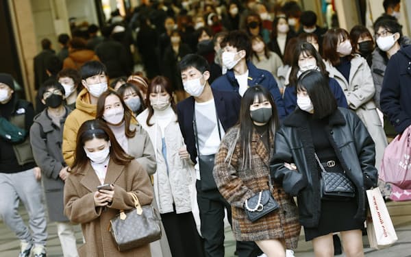 　大阪・ミナミを歩くマスク姿の人たち＝1月