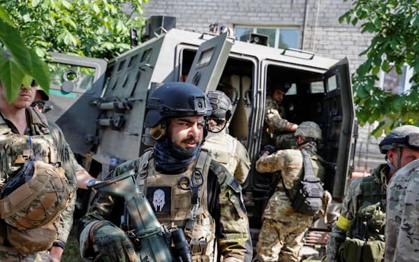 要衝のセベロドネツクで、戦闘車両の近くに立つウクライナ側の外国人部隊（2日、ロイター＝共同）