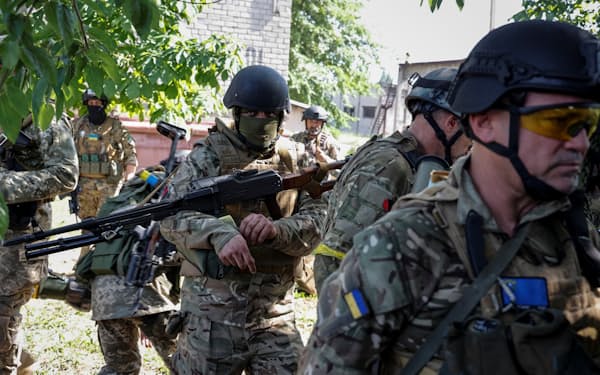 東部セベロドネツクで武器を持って歩くウクライナ側の外国人志願兵ら（2日）=ロイター