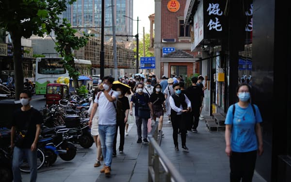 ６日朝、マスクをして上海の通りを歩く人々＝ロイター