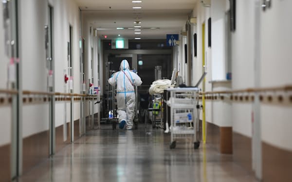 新型コロナウイルスに感染した患者の病室に向かう看護師（9日、大阪府守口市の守口生野記念病院）