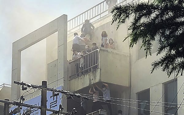 　9日、韓国・大邱のビルで起きた火災で救助を待つ人たち（聯合＝共同）