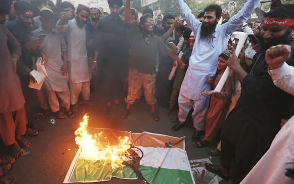 パキスタン北東部のラホールで、インドの国旗を焼くイスラム教徒ら（８日）＝ＡＰ