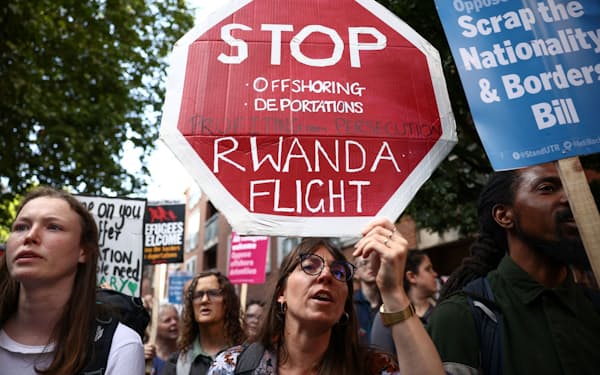 英内務省の建物の前で、ルワンダへの難民移送計画に抗議する人々（13日）＝ロイター