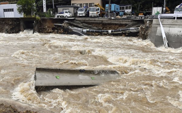 2021年8月の大雨で増水した広島市安佐北区の鈴張川。後方は崩落した道路＝共同